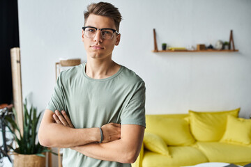 charismatic man in his 20s with brown hair and vision glasses in living room folding cross arms