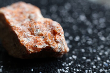 orchid calcite mineral stone on a black glitter background close-up macro photography