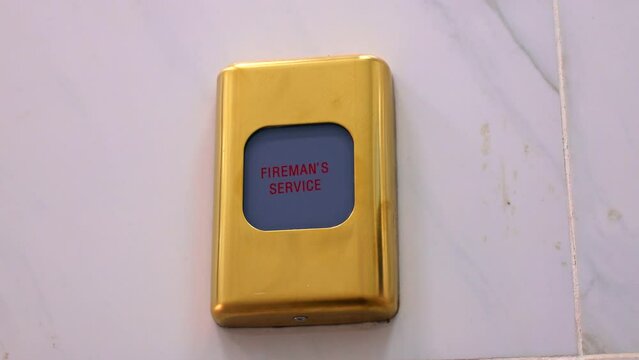 Emergency fire alarm switch with Fireman's service text on the wall