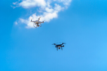 Two drones flying in the blue sky