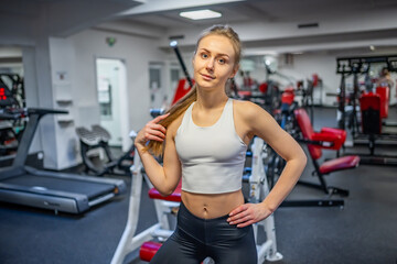 Fototapeta na wymiar Young sporty woman wearing sportswear posing before doing exercise with fitness equipment at gym, she exercise for strong and good 