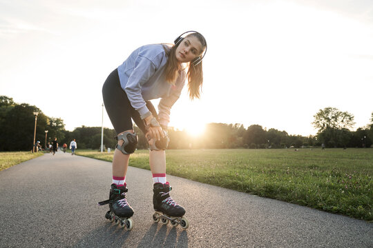 Young woman getting ready for  rollerblading in the park