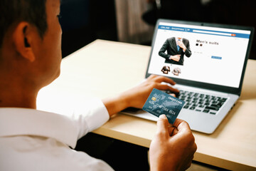 Young man use credit card for shopping payment online on laptop computer application or website. E-commerce and online shopping concept. uds