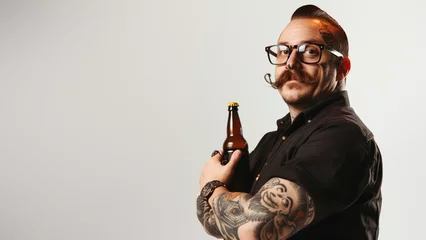 Fotobehang A stylish man with glasses holding a beer bottle, symbolizing a break from the conventional © Fxquadro