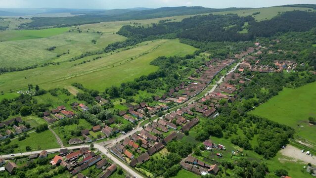 Panoramic aerial perspective of Viscri Village. Countryside of Romania perspective from above. Small village surrounded by forest and agriculture fields. Green landscape. Tranquil landscape. Backward