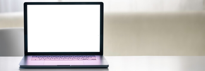 Laptop with a blank white screen on a blurred light background.