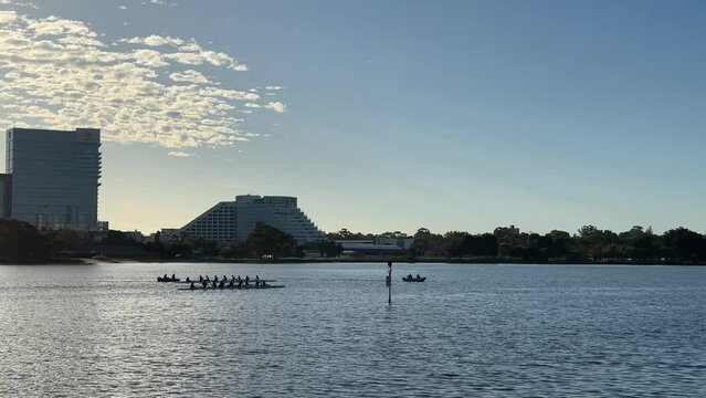 Competition, Endurance, Stamina. Early morning rowers ready for training session on the Swan River.  Crown Casino in the background in Perth, Western Australia.