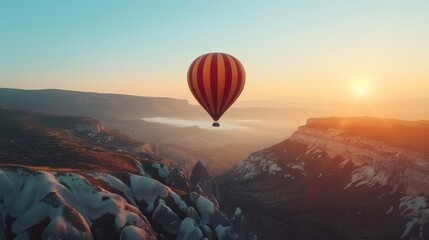 Hot air balloon over snowy mountains at sunrise.