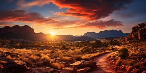 a sunset over a desert landscape - obrazy, fototapety, plakaty