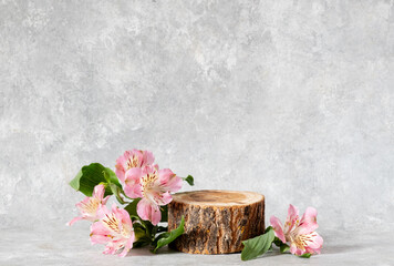 Wooden round podium and pink alstroemeria flowers. Still life for presentation of goods. Copy space
