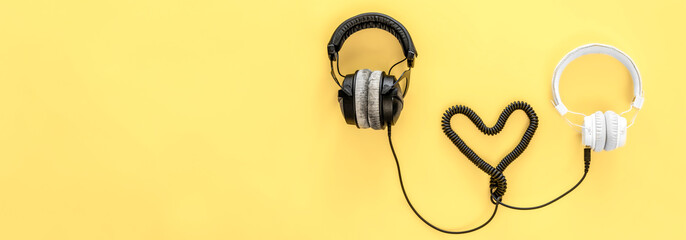 Flat lay musical background with black and white headphones.