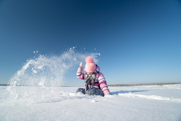 Fototapeta na wymiar girl in a pink hat with a pompom, winter, snow