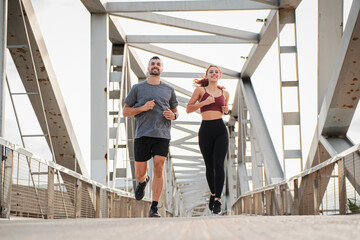 Young couple running for health, wellness or training for a marathon, competition or race, showing...