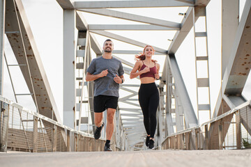 Young couple running for health, wellness or training for a marathon, competition or race, showing effort and endurance enjoying the cardio sport. Workout of a fitness man and athletic woman jogging