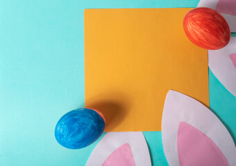 Easter eggs and blank paper card with space for text on blue background. Minimal concept