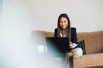 Smiling professional on a video call from the office couch