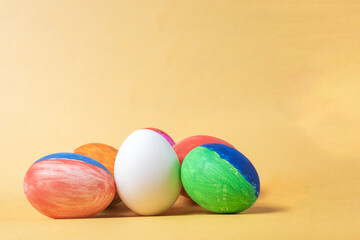 Colorful painted easter eggs on a yellow background with copy space.