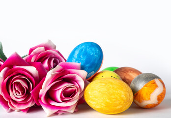 Colorful painted easter eggs and pink roses on white background, selective focus