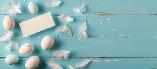 Easter-themed banner featuring eggs and feathers on a blue wooden background, highlighting a minimalistic concept, captured from a top view. Includes a card with space for text.