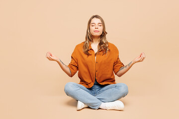 Full body young woman wear orange shirt casual clothes sits hold spread hands in yoga om aum...