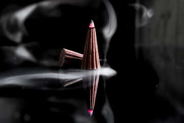 reflection of thick white smoke from burning incense, incense and wishes on an isolated black...