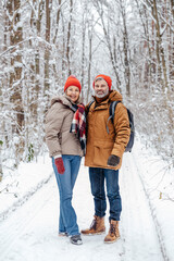 Fototapeta na wymiar Happy mature couple in a snowy forest