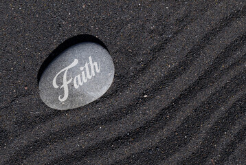 Faith stone on black sand