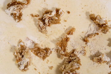 Close up of cake crumbs on table. Crumbs are brown and white