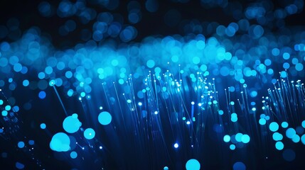 Close-up view of illuminated fiber optic strands against a black and blue blurred backdrop. - obrazy, fototapety, plakaty