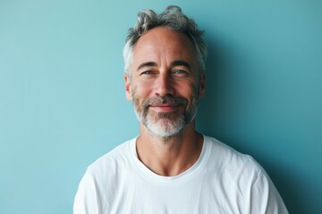 Portrait of handsome mature man with grey hair and beard on blue background - obrazy, fototapety, plakaty
