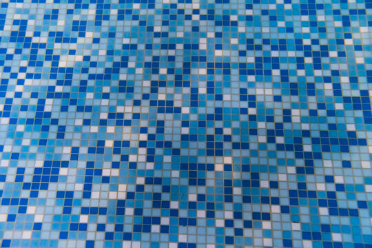 Underwater photo, the bottom of a pool with small tiles.