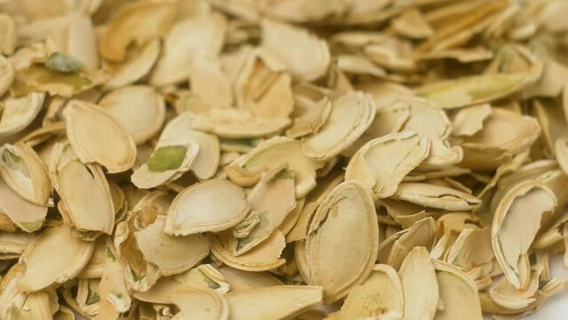 Heap of agricultural waste of husked pumpkin shells removed from peeled with seeds stacked together for recycling and for burning purpose. Macro close up pile pumpkin husks or shell