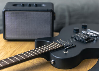 Fototapeta na wymiar Black electric guitar and speaker close-up. Guitar amplifier, musical equipment.