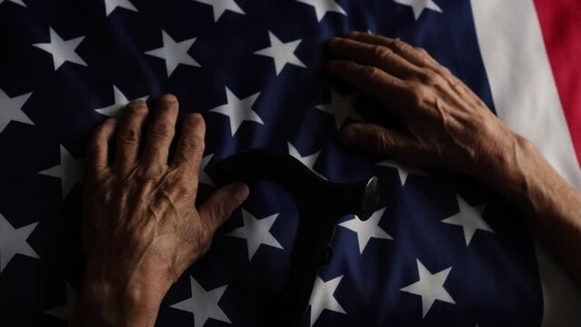 old man's hands holding a flag
America. patriotism and feelings of pride. pensioner with USA flag. Presidential election, American Independence Day