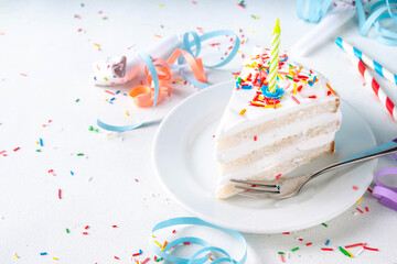 Birthday cake slice on birthday party decorated table.  Slice of Birthday Cake with white whipped...
