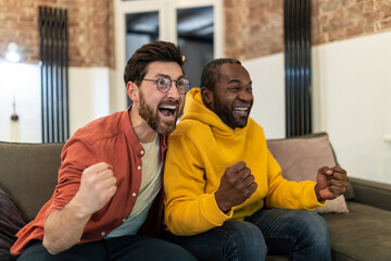 Two friends watching tv and looking excited and emotional