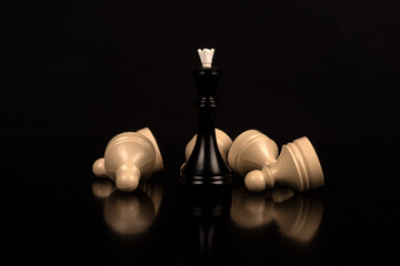 Black queen victory white fallen pawn pieces in chess battle. Strategy win.