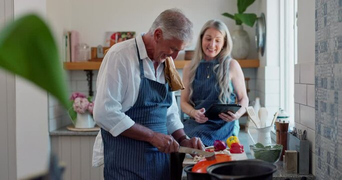 Old couple, cooking and tablet or online recipe in kitchen with raw vegetables or prepare, nutrition or dinner. Man, woman and internet search at stove or healthy lunch or retirement, bonding or food