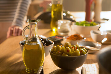 Healthy and fresh green and black olives in separate bowls, with olive oil in a glass bottle....