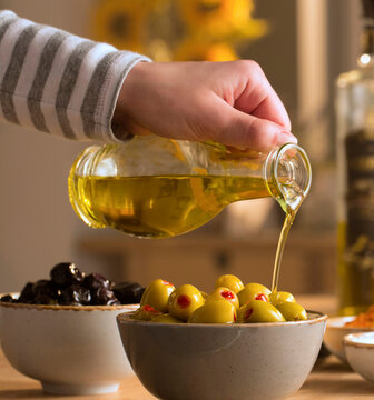Green and black olives in their bowls with fresh olive oil pouring over them