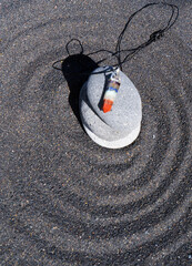 Healing crystals pendulum on black sand background