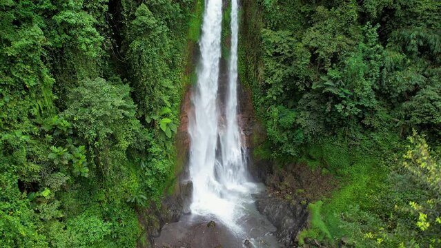Rising up aerial footage of Gitgit waterfall on cloudy day. Bali, Indonesia.