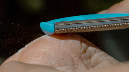 MACRO: Detailed closeup of showing removal of dry skin with a specialized file.