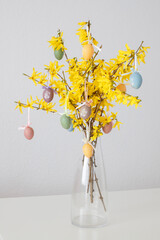 vase with Easter home decor. Easter eggs on forsythia