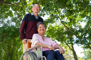 Elderly couples or caregivers take care of the patient in a wheelchair. Concept of a happy retirement with care from a caregiver and Savings and senior health insurance, a Happy Family