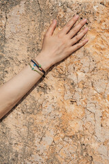 Woman hand with different bracelets on the old stone wall - 767074558