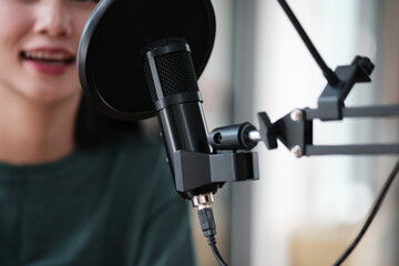 A woman is sitting in front of a microphone