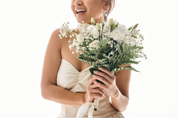 cropped shot of smiling young woman with white flowers bouquet in light background