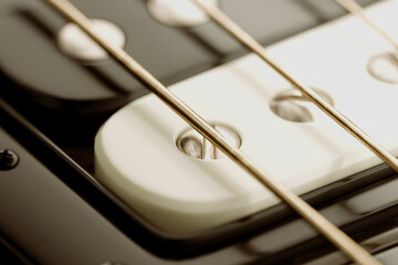 Intricate Close-up View: White Electric Guitar Pickup and Strings