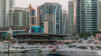 Dubai Marina towers and yachts reflected in water of canal in Dubai day to night timelapse